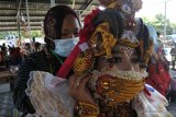 Orang tua membantu anaknya mengenakan masker sebelum mengikuti virtual World Kids Carnival (WKC) 2020 di Jember, Jawa Timur, Minggu (22/11/2020). WKC tersebut diikuti 13 negara di lima benua, yang digelar secara luring dan daring di masa pandemi COVID-19, sambil membawa pesan perdamaian, kreativitas, dan keselamatan dalam satu tema 