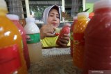 Perajin memasang label pada botol berisi jus buah asli di Kelurahan Kampungdalem, Kota Kediri, Jawa Timur, Senin (23/11/2020). Jus buah asli seharga Rp7.000 per botol yang hanya mampu bertahan hingga 3 hari pada suhu ruangan tersebut dinilai lebih menyehatkan daripada minuman botol beraroma buah yang umumnya berpengawet. Antara Jatim/Prasetia Fauzani/um