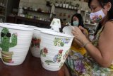 Perajin menguaskan kertas tisu bergambar saat membuat pot decoupage di kawasan Sepande, Candi, Sidoarjo, Jawa Timur, Selasa (24/11/2020). Untuk meningkatkan nilai jual, Perajin pot berkreasi dengan menggambar menggunakan teknik decoupage. Antara Jatim/Umarul Faruq/um