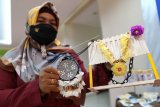 Seorang perajin dari kelompok UMKM Salvador Dali menunjukan produk kerajinan tangan kalung pada pameran UMKM di Kantor Perwakilan Bank Indonesia (BI) Provinsi Gorontalo di Kota Gorontalo, Gorontalo, Senin (23/11/2020). UMKM tersebut membuat berbagai produk dengan memanfaatkan sisik ikan karang menjadi bros, kalung dan hiasan meja yang dijual dengan harga mulai dari Rp20 ribu hingga Rp60 ribu per buah. ANTARA FOTO/Adiwinata Solihin/foc.