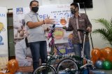 Chief Operating Officer ACC Ezar Kumendong (kiri) menyerahkan hadiah sepeda brompton kepada salah satu pemenang undian pelanggan berseri ACC di kantor ACC Surabaya, Jawa Timur, Kamis (26/11/2020). Program undian pelanggan berseri berupa sepeda brompton dan hadiah logam mulai 5 gram merupakan undian bagi pelanggan setia Astra Credit Companies (ACC) yang mengambil fasilitas dana ACC. Antara Jatim/Umarul Faruq/Mas