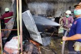 Petugas melakukan pembasahan area gudang suku cadang kendaraan yang terbakar di Tulungagung, Jawa Timur, Kamis (26/11/2020). Gudang suku cadang kendaraan bermotor di pusat Kota Tulungagung itu terbakar diduga akibat konsleting listrik pemanas air. Antara Jatim/Destyan Sujarwoko/Um