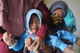 Petugas menyuntikkan Vaksin Rubella kepada siswa di SD Exelen, Pamekasan, Jawa Timur, Jumat (27/11/2020). Memasuki Bulan Imunisasi Anak Sekolah (BIAS) Dinkes Pamekasan  mendatangi sekolah-sekolah guna memberikan vaksin Rubella dan Difteri Tetanus. Antara Jatim/Saiful Bahri/mas.