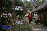 Warga berjalan di kawasan Desa Wisata Saung Ciburial, Samarang, Kabupaten Garut, Jawa Barat, Senin (30/11/2020). Bank bjb hadir mendukung program Pemerintah Provinsi Jawa Barat yakni One Village One Company (OVOC) dengan membuka percepatan akses keuangan produk-produk perbankan (tabungan dan kredit) di desa guna menciptakan desa yang maju dan mandiri secara ekonomi serta pemberdayaan masyarakat desa. ANTARA JABAR/Candra Yanuarsyah/agr