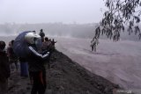 Warga melihat aliran lahar panas atau awan panas di kawasan Besuk Kobokan, Pronojiwo, Lumajang, Jawa Timur, Selasa (1/12/2020). Sejumlah truk, alat berat penambang pasir terendam aliran lahar panas berupa pasir dan akses jalan antar kecamatan di Lumajang terputus. Antara Jatim/Seno/Um