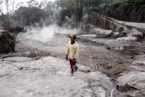 Warga melintas di jalur lahar panas Gunung Semeru di kawasan Pronojiwo, Lumajang, Jawa Timur, Rabu (2/12/2020). Gunung Semeru mengalami erupsi yang menyebabkan awan panas letusan terus meluncur ke arah Curah Besuk Kobokan sepanjang 11 kilometer dengan durasi kemunculan awan panas selama tiga jam serta status level II atau waspada. Antara Jatim/Umarul Faruq/Mas