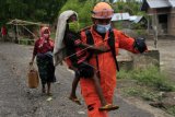 Seorang anggota Basarnas menggendong bocah ketika tim gabungan mengevakuasi warga yang masih bertahan dalam Kawasan Rawan Bencana (KRB) III erupsi Gunung Ili Lewotolok di Kecamatan Ile Ape Timur, Lembata, NTT Kamis (3/12/2020). Badan Penanggulangan Bencana Daerah (BPBD) menyebutkan sampai dengan Kamis (3/12) jumlah pengungsi yang sudah dievakuasi mencapai 7.968 jiwa, sementara yang belum dievakuasi mencapai 13 ribu jiwa dengan alasan ingin tetap bertahan. ANTARA FOTO/Kornelis Kaha/nym.