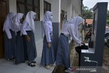 Sejumlah siswi mengantre mencuci tangan saat mengikuti kegiatan pembelajaran tatap muka di SMAN 30 Garut, Cihurip, Kabupaten Garut, Jawa Barat, Kamis (3/12/2020). Sebanyak 15 SMA dan SMK di Garut Selatan telah mengikuti pembelajaran tatap muka dengan perizinan Dinas Pendidikan Jawa Barat dan Kecamatan setempat dengan tetap menerapkan protokol kesehatan ketat. ANTARA JABAR/Candra Yanuarsyah/agr