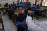 Petugas kesehatan menyuntikan vaksin Tetanus Difteri (TD) kepada siswa saat kegiatan Bulan Imunisasi Anak Sekolah (BIAS) di SD Negeri 1 Klakah, Selo, Boyolali, Jawa Tengah, Kamis (3/12/2020). Imunisasi Difteri Tetanus (DT) dan TD diberikan kepada siswa sekolah yang berada di kaki Gunung Merapi untuk mencegah penyakit yang disebabkan infeksi. ANTARA FOTO/Aloysius Jarot Nugroho/rwa. 