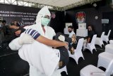 Petugas KPPS menggunakan baju pelindung (Hazmat) mengevakuasi pemilih yang tiba-tiba mengalami gangguan kesehatan saat simulasi pemungutan suara Pemilu 2020 di Alun-Alun Kota Blitar, Jawa timur, Kamis (3/12/2020). Simulasi pemungutan suara dengan menerapkan protokol kesehatan serta penanganan pemilih khusus disabilitas dan diduga terpapar COVID-19 tersebut bertujuan untuk menghindari penularan COVID-19 pada pelaksanaan Pemilu 2020, serta menciptakan pemilu yang aman dan sehat. Antara Jatim/Irfan Anshori/Um