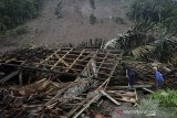 Petugas dan warga membereskan puing-piung rumah akibat tanah longsor di Desa Sukamulya, Talegong, Kabupaten Garut, Jawa Barat, Kamis (3/12/2020). Hujan deras sejak pagi mengakibatkan 15 rumah tertimbun longsor dan 40 terancam longsor serta menutup jalan perbatasan antara Kabupaten Garut dan Kabupaten Bandung dan dalam tidak ada korban jiwa dalam peristiwa tersebut. ANTARA JABAR/Candra Yanuarsyah/agr