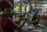 Konsumen melakukan transaksi pembayaran menggunakan aplikasi uang elektronik BJB DigiCash di usaha kuliner dan kopi Warung Pinus, Sagalaherang, Kabupaten Subang, Jawa Barat, Jumat (4/12/2020).  PT Bank Pembangunan Daerah Jawa Barat dan Banten, Tbk. (Bank BJB) hadir mendukung program Pemerintah Jawa Barat untuk membangun Kawasan  Rebana Metropolitan yakni salah satunya dengan transformasi transaksi dan kredit perbankan secara digital bagi masyarakat dan pelaku umkm melalui aplikasi BJB Digi dan BJB DigiCash. ANTARA JABAR/Novrian Arbi/agr