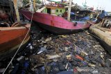 Warga berada di sekitar oli bekas yang bercampur sampah di sungai Prajagumiwang, Karangsong, Indramayu, Jawa Barat, Jumat (5/12/2020). Limbah oli bekas dari mesin kapal nelayan banyak dibuang sembarangan hingga mencemari sungai dan mengancam ekosistem di perairan tersebut. ANTARA JABAR/Dedhez Anggara/agr