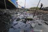 Warga berada di sekitar oli bekas yang bercampur sampah di sungai Prajagumiwang, Karangsong, Indramayu, Jawa Barat, Jumat (5/12/2020). Limbah oli bekas dari mesin kapal nelayan banyak dibuang sembarangan hingga mencemari sungai dan mengancam ekosistem di perairan tersebut. ANTARA JABAR/Dedhez Anggara/agr