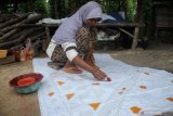 Perajin menyelesaikan proses pembuatan batik tulis, di Desa Klampar,  Pamekasan, Jawa Timur, Jumat (4/12/2020). Dalam sebulan terakhir produksi batik di daerah itu naik sekitar 25 persen atau naik dari 200 potong menjadi 250 potong hasil tiap perajin per pekan, karena meningkatnya permintaan dari sejumlah daerah. Antara Jatim/Saiful Bahri/mas.