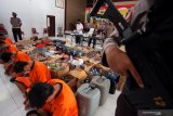 Polisi menunjukkan sejumlah tersangka bersama ratusan alat bukti minuman keras dan obat-obatan berbahaya yang berhasil diamankan saat rilis operasi cipta kondisi di Mapolres Blitar Kota, Jawa Timur, Jumat (4/12/2020). Operasi cipta kondisi tersebut bertujuan untuk menjaga situasi kamtibmas di wilayah itu, terutama jelang H-5 hingga hari H pelaksanaan Pilkada Serentak 2020. Antara Jatim/Irfan Anshori/mas.