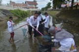 Masyarakat yang tergabung dalam komunitas lingkungan mengenakan masker membersihkan sampah plastik bekas dan sampah limbah rumahtangga di pintu air Sungai Krueng Daroy, Banda Aceh, Aceh, Sabtu (5/12/2020). Gerakan bersih sungai sepanjang daerah aliran sungai tersebut untuk mengantisipasi banjir memasuki musim penghujan dan sekaligus sosialisasi kepada warga peduli lingkungan. Antara Aceh/Ampelsa.