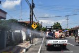 Petugas Palang Merah Indonesia (PMI) menyemprotkan cairan disinfektan di lingkungan sekitar rumah warga yang meninggal akibat positif COVID-19 di Kota Madiun, Jawa Timur, Sabtu (5/12/2020). Penyemprotan tersebut dimaksudkan untuk pencegahan penularan COVID-19 di Kota Madiun. Antara Jatim/Siswowidodo/Um