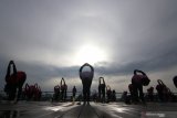 Warga melakukan gerakan yoga di Pulau Wangi, Pantai Boom, Banyuwangi, Jawa Timur, Minggu (6/12/2020). Olahraga yoga yang memiliki banyak manfaat seperti mengolah pernafasan, menurunkan berat badan hingga menurunkan stres itu, pada masa pandemi COVID-19 ini banyak diminati masyarakat karena dipercaya dapat meningkatkan imunitas. Antara Jatim/Budi Candra Setya/mas.