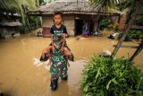 Anggota Babinsa TNI Kodim 0103 Aceh Utara membantu evakuasi korban banjir di Desa Hasan Kareung, Blang Mangat, Lhokseumawe, Aceh, Sabtu (5/12/2020). Data Badan Penanggulangan Bencana Daerah (BPBD) menyebutkan bencana banjir terus meluas, merendam 502 desa di 20 kecamatan di Aceh Utara, menyebabkan sekitar seribu warga mengungsi. ANTARA FOTO/Rahmad/foc.