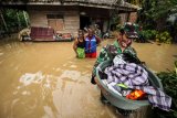 Anggota Babinsa TNI Kodim 0103 Aceh Utara membantu evakuasi korban banjir di Desa Hasan Kareung, Blang Mangat, Lhokseumawe, Aceh, Sabtu (5/12/2020). Data Badan Penanggulangan Bencana Daerah (BPBD) menyebutkan bencana banjir terus meluas, merendam 502 desa di 20 kecamatan di Aceh Utara, menyebabkan sekitar seribu warga mengungsi. ANTARA FOTO/Rahmad/foc.