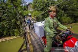 Petugas Panitia Pemilihan Kecamatan (PPK) di kawal pihak kepolisian membawa logistik Pilkada untuk didistribusikan ke lokasi-lokasi pedalaman yang sulit dijangkau menuju Desa Haratai, Kecamatan Loksado, Kabupaten Hulu Sungai Selatan, Kalimantan Selatan, Selasa (8/12/2020). KPU Kabupaten Hulu Sungai Selatan mendistribusikan logistik Pilkada serentak tahun 2020 ke wilayah desa terpencil di kaki pegunungan meratus di Kabupaten Hulu Sungai Selatan yang hanya dapat ditempuh dengan menggunakan sepeda motor dan ditargetkan selesai pada Selasa (8/12). Foto Antaranews Kalsel/Bayu Pratama S.