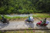 Personel TNI mengawal petugas Panitia Pemilihan Kecamatan (PPK) membawa logistik Pilkada melintasi jalan menuju desa Haratai saat mendistribusikan ke lokasi-lokasi pedalaman yang sulit dijangkau di Kecamatan Loksado, Kabupaten Hulu Sungai Selatan, Kalimantan Selatan, Selasa (8/12/2020). KPU Kabupaten Hulu Sungai Selatan mendistribusikan logistik Pilkada serentak tahun 2020 ke wilayah desa terpencil di kaki pegunungan meratus di Kabupaten Hulu Sungai Selatan yang hanya dapat ditempuh dengan menggunakan sepeda motor dan ditargetkan selesai pada Selasa (8/12). Foto Antaranews Kalsel/Bayu Pratama S.