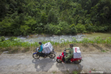 Petugas Panitia Pemilihan Kecamatan (PPK) dibantu warga membawa logistik Pilkada untuk didistribusikan menuju Desa Haratai, Kecamatan Loksado, Kabupaten Hulu Sungai Selatan, Kalimantan Selatan, Selasa (8/12/2020). KPU Kabupaten Hulu Sungai Selatan mendistribusikan logistik Pilkada serentak tahun 2020 ke wilayah desa terpencil di kaki pegunungan Meratus di Kabupaten Hulu Sungai Selatan yang hanya dapat ditempuh dengan menggunakan sepeda motor dan ditargetkan selesai pada Selasa (8/12). ANTARA FOTO/Bayu Pratama S/hp. 