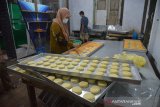 Perajin mengenakan masker memproduksi roti di salah satu pabrik roti rakyat di Gampong Rima, kecamatan Peukan Bada, Kabupaten Aceh Besar, Aceh, Selasa (8/12/2020. Usaha produksi roti yang dikelola Badan Usaha Milik Gampong/Desa (BUMG) bertujuan meningkatkan perekonomian masyarakat desa di tengah pandemi COVID-19 itu mulai membaik menyusul terbukanya peluang pasar di sejumlah sekolah, pesantren serta pusat perbelanjaan dengan omset penjualan mencapai 1.000 hingga 1.500 roti per hari. . Antara Aceh/Ampelsa.