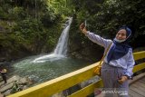 Pengunjung berfoto di wisata Air Terjun Haratai, Kecamatan Loksado, Kabupaten Hulu Sungai Selatan, Kalimantan Selatan, Selasa (8/12/2020). Air Terjun Haratai yang dikelola oleh kelompok usaha perhutanan sosial tersebut merupakan salah satu daya tarik pariwisata alam yang terus dikembangkan untuk menarik kunjungan wisatawan ke wilayah Kalimantan Selatan. Foto Antaranews Kalsel/Bayu Pratama S.