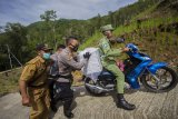 Anggota kepolisian bersama TNI dan Petugas Panitia Pemilihan Kecamatan (PPK) membantu mendorong sepeda motor milik warga yang membawa logistik Pilkada saat melintasi tanjakan menuju desa Haratai di Kecamatan Loksado, Kabupaten Hulu Sungai Selatan, Kalimantan Selatan, Selasa (8/12/2020). KPU Kabupaten Hulu Sungai Selatan mendistribusikan logistik Pilkada serentak tahun 2020 ke wilayah desa terpencil di kaki pegunungan Meratus di Kabupaten Hulu Sungai Selatan yang hanya dapat ditempuh dengan menggunakan sepeda motor dan ditargetkan selesai pada Selasa (8/12). ANTARA FOTO/Bayu Pratama S/nym.