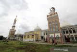 Warga melintas di sekitar menara masjid Syech Abdul Manan Islamic Center yang roboh di Indramayu, Jawa Barat, Rabu (9/12/2020). Menara Masjid yang diresmikan tahun 2018 itu roboh akibat terpaan angin kencang beberapa hari lalu. ANTARA JABAR/Dedhez Anggara/agr