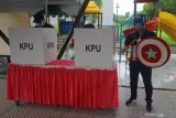 Petugas KPPS berkostum pahlawan super (super hero) berjaga di samping bilik pencoblosan di TPS 14 di kompleks Perumahan Citraland, Surabaya, Jawa Timur, Rabu (9/12/2020). Penggunaan kostum pahlawan super tersebut bertujuan untuk menarik perhatian masyarakat agar datang dan menggunakan hak pilihnya pada Pilkada Kota Surabaya 2020. Antara Jatim/Moch Asim. 