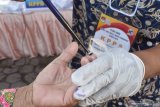Petugas Kelompok Penyelenggara Pemungutan Suara (KPPS) menandai tinta pada jari pemilih saat Pilkada di Kabupaten Ponorogo, Jawa Timur, Rabu (9/12/2020). Pilkada Kabupaten Ponorogo diikuti dua pasangan calon bupati-wakil bupati, yaitu Sugiri Sancoko-Lisdyarita dan Ipong Musclissoni-Bambang Tri Wahono dengan jumlah pemilih yang terdaftar di KPU setempat 759.045 orang. Antara Jatim/Siswowidodo/mas.