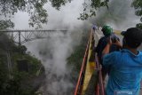 Warga melihat lahar dingin Gunung Semeru di Jembatan Piket Nol, Candipuro, Lumajang, Jawa Timur, Sabtu (12/12/2020). Banjir lahar dingin di Daerah Aliran Sungai (DAS) Gunung Semeru membawa lava panas, mengeluarkan asap dan berbau belerang. COVID-19. Antara Jatim/Seno/Um