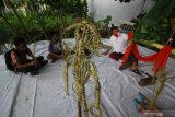 Seniman Surabaya Meimura (kanan) mementaskan wayang suket bersama anak-anak di Sanggar Anak Merdeka Indonesia di Surabaya, Jawa Timur, Selasa (15/12/2020). Kegiatan tersebut bertujuan untuk memberikan ruang kreatifitas pada anak di tengah pandemi COVID-19 sekaligus mengenalkan khazanah budaya Indonesia melalui wayang suket. Antara Jatim/Moch Asim.