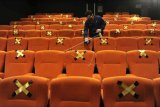 Karyawan membersihkan kursi penonton saat hari pertama pembukaan kembali Cinepolis Cinemas di Lippo Mall Kuta, Badung, Bali, Rabu (16/12/2020). Sejumlah bioskop di wilayah Bali kembali beroperasi dengan menerapkan protokol kesehatan COVID-19 sesuai dengan peraturan dan rekomendasi pemerintah seperti membatasi kapasitas di dalam studio menjadi 50 persen dan mewajibkan pengunjung untuk mengenakan masker. ANTARA FOTO/Fikri Yusuf/nym.