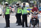 Polisi menghentikan pengendara motor yang tidak mengenakan masker saat Operasi Yustisi Penegakan Hukum Protokol Kesehatan di Jalan Tambaksari, Surabaya, Jawa Timur, Rabu (16/12/2020). Dalam razia yang bertujuan untuk menegakkan kedisiplinan warga untuk menerapkan protokol kesehatan tersebut menjaring sejumlah warga yang tidak mengenakan masker dengan benar maupun tidak mengenakan masker sama sekali. Antara Jatim/Didik