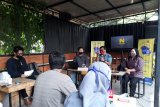 Pejabat Dinas Perdagangan dan Perindustrian Kota Kediri saat memberikan suvenir ke narasumber pengusaha kopi di sebuah kafe Kota Kediri, Jawa Timur, Kamis (10/12/2020). Dinas tersebut menyelenggarakan worshop bagi pengusaha milenial agar mereka tetap bersemangat usaha di tengah pandemi COVID-19. Antara Jatim/ Asmaul Chusna