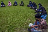 Sejumlah santri Al-Hasan membaca Al Quran metode Qiroati atau dibaca secara langsung tanpa dieja di Alun-alun Kabupaten Ciamis, Jawa Barat, Jumat (18/12/2020). Kegiatan membaca Al Quran di ruang terbuka dengan menerapkan pratokol kesehatan itu, untuk menghilangkan kejenuhan santri mengaji di Pondok Pesantren di tengah Pandemi COVID-19. ANTARA JABAR/Adeng Bustomi/agr