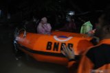 Relawan mengevakuasi warga  saat banjir di Kelurahan Gladak Anyar, Pamekasan, Jawa Timur, Jumat (18/12/2020). Hujan yang mengguyur daerah itu selama lebih dari enam jam menyebabkan  ratusan pemukiman warga terendam banjir yang tersebar di beberapa titik. Antara Jatim/Saiful Bahri/Um