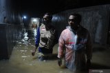 Relawan berkeliling kampung guna mencari warga terdampak banjir yang membutuhkan pertolongan  di Kelurahan Gladak Anyar, Pamekasan, Jawa Timur, Jumat (18/12/2020). Hujan yang mengguyur daerah itu selama lebih dari enam jam menyebabkan  ratusan pemukiman warga terendam banjir yang tersebar di beberapa titik. Antara Jatim/Saiful Bahri/Um