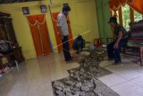 Warga mengukur kedalaman tanah yang mengalami penurunan akibat bencana tanah bergerak di Desa Bodas, Pekalongan, Jawa Tengah, Senin (21/12/2020). Bencana tanah bergerak akibat hujan deras tersebut mengakibatkan tanah amblas di kawasan permukiman warga dengan rata-rata kedalaman sekitar 20-40 centimeter dan lahan pertanian amblas sedalam 10-15 meter dengan lebar 250 meter dan panjang 1,5 kilometer yang berdampak pada 95 kepala keluarga. ANTARA FOTO/Harviyan Perdana Putra/nym.