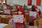 Sejak Maret 2020, aktivitas belajar mengajar sejumlah sekolah berbagai tingkatan pendidikan lumpuh seketika akibat pandemi COVID-19 yang mulai mewabah di Indonesia. 



Mulai sekolah PAUD, SD, SMP, SMA serta pesantren hingga perguruan tinggi tutup dan proses belajar mengajar dihentikan guna mencengah penyebaran COVID-19. 



Aktivitas belajar mulai diterapkan kembali setelah kasus COVID-19 mereda menurut pembagian zona wilayah yang dinilai aman dari penyebaran COVID-19



Proses belajar mengajar di sekolah harus menerapkan disiplin protokol kesehatan setelah adanya kesepakatan antara orang tua murid dengan pihak sekolah serta arahan dari pemerintah setempat.



Pihak sekolah menyatakan, aktivitas belajar yang kembali dimulai sejak dua bulan terakhir menjelang akhit tahun 2020 itu dibatasi, dalam satu lokal hanya dihadiri 50 persen dari total murid dengan menerapkan protokol kesehatan menggunakan. masker, jagar jarak dan cucu tangan. 



Sebelum murid memasuki ruang belajar, pihak sekolah juga melakukan penyemprotan cairan disinfektan untuk sterilisasi bebas dari COVID-19.



Selain pembatasan jumlah murid, pihak sekolah juga mengurangi jam belajar masing masing kelas belajar satu jam dan kemudian diganti dengan murid lainnya dengan waktu belajar yang sama. 



Pemberlakukan tersebut tidak hanya diterapkan di sekolah umum, melainkan juga di dayah atau pesantren untuk mencegah penyebaran COVID-19 yang sudah menjadi tanggung jawab semua pihak .



Para orangtua dan murid sekolah berharap kasus COVID-19 segera berlalu, sehingga aktivitas belajar dan mengajar kembali berjalan normal.

