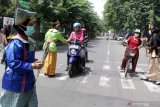 Tenaga kesehatan memakai pakaian adat membagikan bunga kepada pengendara di depan RS Siti Hajar Sidoarjo, Jawa Timur, Senin (21/12/2020). Kegiatan tersebut dalam rangka memperingati Hari Ibu yang jatuh pada 22 Desember. Antara Jatim/Umarul Faruq/Mas