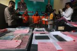 Polisi menunjukkan barang bukti dan tersangka saat ungkap kasus pemalsuan dokumen hasil tes cepat (rapid test) di Polres Pelabuhan Tanjung Perak Surabaya, Jawa Timur, Senin (21/12/2020). Polres Pelabuhan Tanjung Perak Surabaya menangkap tiga tersangka atas kasus dugaan membuat dokumen palsu hasil tes cepat (rapid test) dan mengamankan barang bukti beberapa diantaranya satu laptop, stempel, alat cetak, sepuluh lembar hasil rapid test palsu. ANTARA FOTO/Didik Suhartono/aww.