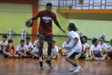 Pebasket Indonesia Jamarr Andre Johnson (kiri) memberikan materi kepada anak-anak peserta pelatihan bola basket di GOR Merpati, Denpasar, Bali, Rabu (23/12/2020). Pelatihan tersebut dilakukan untuk meningkatkan kemampuan sekaligus memberikan motivasi kepada pebasket usia muda. ANTARA FOTO/Fikri Yusuf/nym.