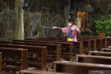 Umat Katolik menyemprot cairan disinfektan di bangku yang akan digunakan untuk misa malam natal di Gereja Maria Ratu Damai Banyuwangi, Kamis (24/12/2020). Guna mencegah penularan Covid 19, perayaan natal dilakukan dengan berbagai penyesuaian seperti memperbanyak frekuensi misa untuk memecah kerumunan umat, membatasi jumlah umat menggunakan tiket tempat duduk bernomor, duduk berjarak, dan misa streaming untuk kelompok renta anak-anak dan orang tua. Antara Jatim/Budi Candra Setya/Um