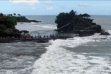 Wisatawan domestik memadati obyek wisata Pantai Tanah Lot saat liburan Natal di Tabanan, Bali, Jumat (25/12/2020). Kunjungan wisatawan domestik di Tanah Lot mengalami peningkatan dengan rata-rata 1.000-1.500 orang saat hari libur yang sebelumnya sempat menurun drastis akibat terdampak COVID-19. ANTARA FOTO/Nyoman Hendra Wibowo/nym.