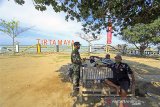 Personel TNI dan Polri mengimbau wisatawan untuk menerapkan protokol kesehatan di objek wisata Pantai Tirtamaya, Indramayu, Jawa Barat, Jumat (25/12/2020). Petugas gabungan terus melakukan pengawasan penerapan protokol kesehatan selama masa liburan Hari Raya Natal 2020 dan tahun baru 2021 untuk mencegah penyebaran COVID-19 di sejumlah objek wisata. ANTARA JABAR/Dedhez Anggara/agr